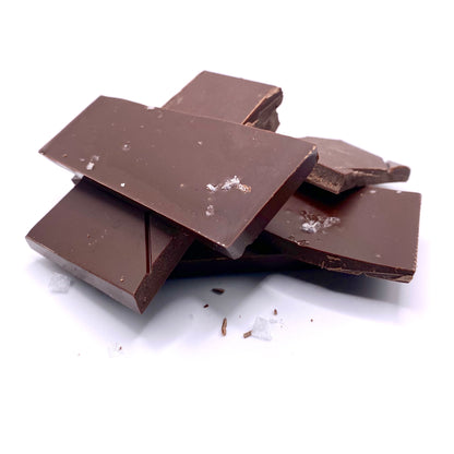 Dark Chocolate with Sea Salt bar broken in to pieces and stacked. 