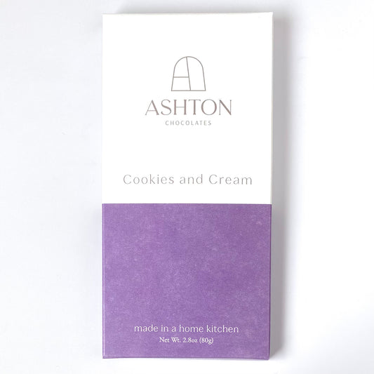 A Cookies and Cream chocolate bar box. Half of the box is white the other half is purple.